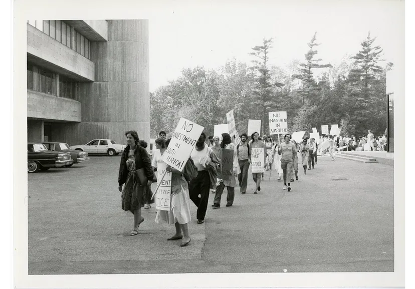 A procession of students holding signs with slogans such as "No investment in South Africa!".